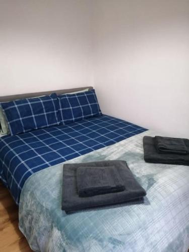 a bed in a room with a blue bedspread and a pillow at Stylish one bed flat with private parking in Aberdeen