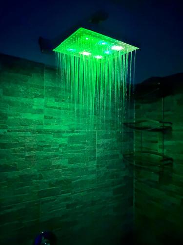 un edificio con luces verdes en una pared en RooMYitalia - Guest House Il Faraone, en Fiumicino