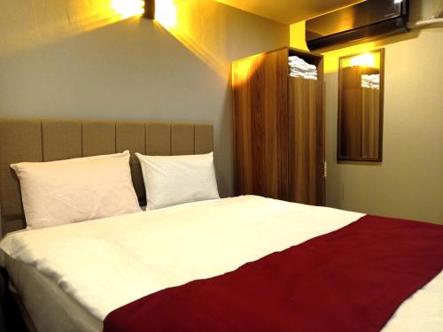 Schlafzimmer mit einem großen Bett mit weißer und roter Bettwäsche in der Unterkunft Grand Marrakech Hotel in Yıldırım