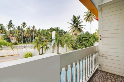 a balcony with palm trees and a street at Star Inn Hotel in Trivandrum
