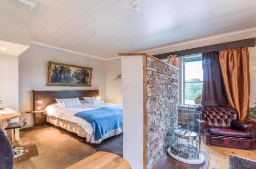 a bedroom with a bed and a stone wall at Skultuna Hotell & Konferens in Skultuna