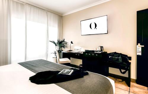 1 dormitorio con 1 cama y escritorio con bolsa en HO Ciudad de Jaén, en Jaén