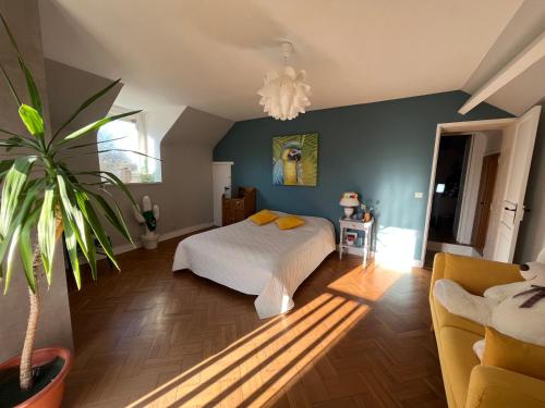 um quarto com uma cama e um vaso de plantas em Maison 80è anniversaire D-Day em Le Manoir