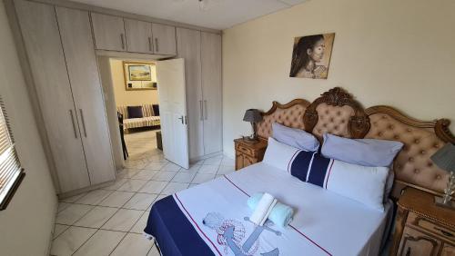 a bedroom with a large bed with a wooden headboard at Garden Oasis Cottage in Windhoek