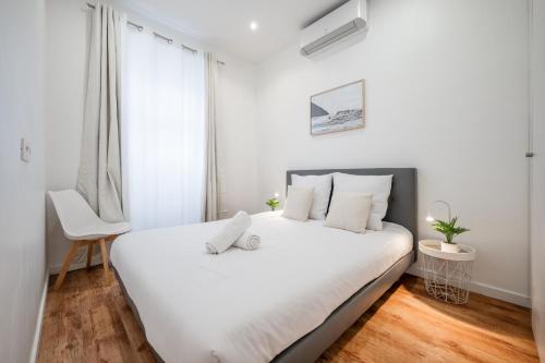 une chambre blanche avec un lit blanc et une fenêtre dans l'établissement Pertinax Cosy 2 pièces au coeur du centre ville de Nice AC, à Nice