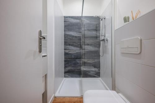 La salle de bains blanche est pourvue d'une douche et de toilettes. dans l'établissement Pertinax Cosy 2 pièces au coeur du centre ville de Nice AC, à Nice