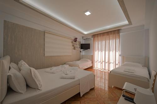 a hotel room with two beds and a television at Hotel Angjelo in Borsh