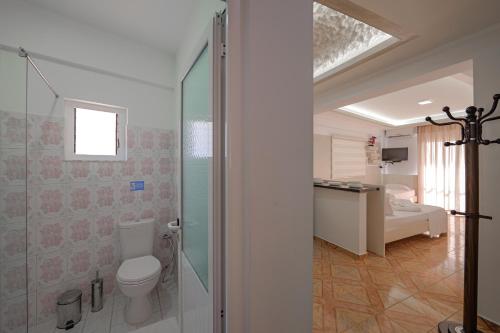 uma casa de banho com um chuveiro, um WC e um lavatório. em Hotel Angjelo em Borsh