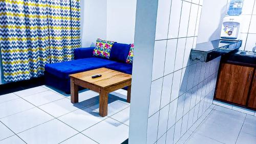 een woonkamer met een blauwe bank en een tafel bij One Bedroom at Bamburi in Mombasa