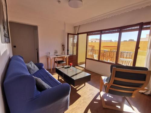 een woonkamer met een blauwe bank en een tafel bij El refugio de Torrijos in Málaga