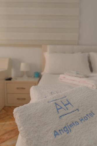 a white bed in a room with a white bedspread at Hotel Angjelo in Borsh