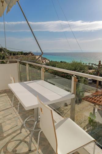 a white table and chairs on a balcony with the ocean at Hotel Angjelo in Borsh