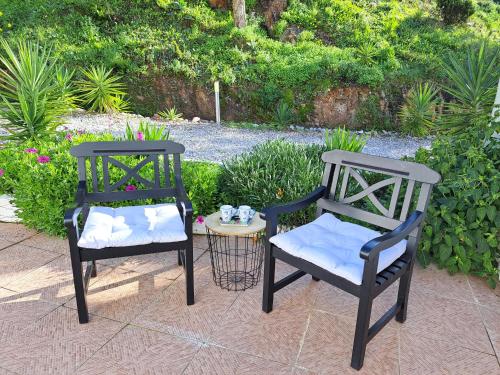 dos sillas negras sentadas junto a una mesa con una mesa lateral en Casa Rochinha en Portimão