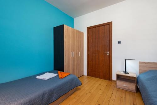 1 dormitorio con 2 camas y puerta de madera en DevIn Coworking & Coliving en Devin