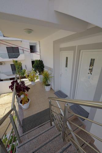 a balcony with potted plants on the stairs at Hotel Angjelo in Borsh