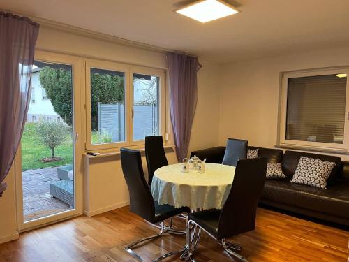 a living room with a table with chairs and a couch at Gemütliche 3 Zimmer Wohnung mit großzügiger Terrasse im Grünen in Reutlingen