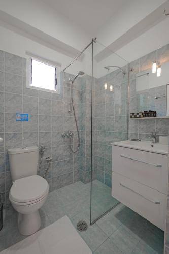 a bathroom with a toilet and a shower and a sink at Hotel Angjelo in Borsh