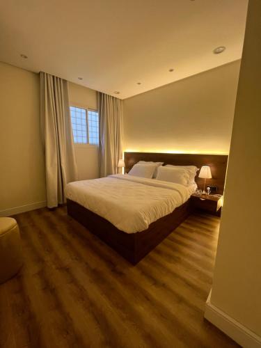 een slaapkamer met een groot bed en een raam bij شقة فاخرة بالقرب من البوليفارد Apartment next to boulevard city- world &arean kingdom in Riyad