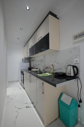 a white kitchen with a sink and a counter at Hotel Angjelo in Borsh