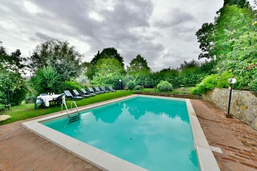 a swimming pool in a backyard with a table and chairs at Agriturismo Corvaia in Radicofani