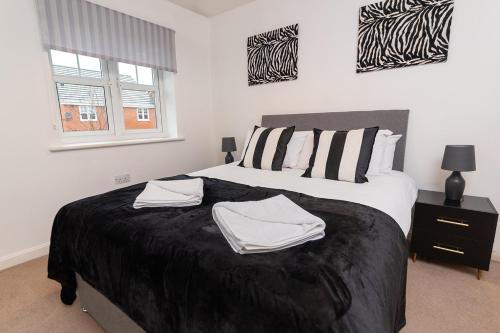 a bedroom with a bed with two towels on it at Pacific House in Thornaby on Tees