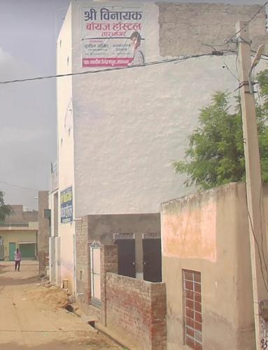 un edificio con un cartel en el costado en Shree Vinayak Hostel Taranagar, en Tārānagar