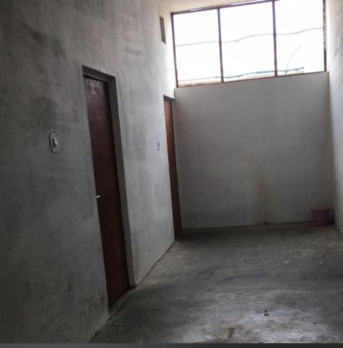 een lege kamer met een deur en een raam bij Shree Vinayak Hostel Taranagar in Tārānagar