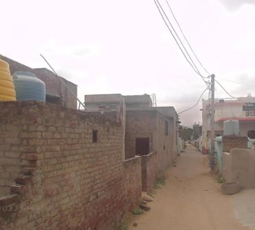 un callejón con una pared de ladrillo junto a una calle en Shree Vinayak Hostel Taranagar, en Tārānagar