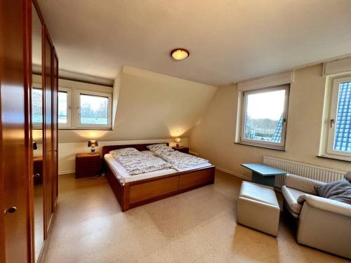 ein kleines Schlafzimmer mit einem Bett und einem Sofa in der Unterkunft Wohnung in Greven - nähe Münster in Greven