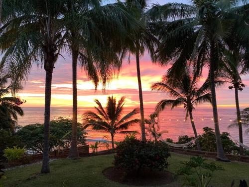 a view of the ocean from a resort with palm trees at Casa Karina, Spectacular Ocean View Pool Oasis in Aticama