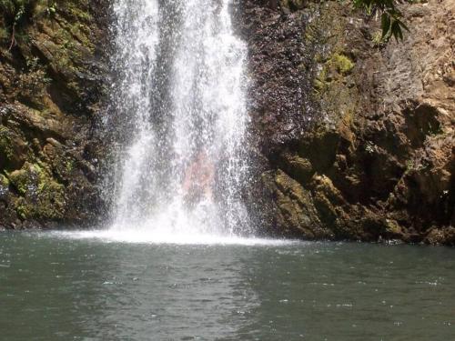 a person is standing in front of a waterfall at Casa Karina, Spectacular Ocean View Pool Oasis in Aticama
