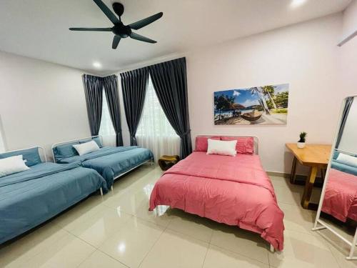 ein Schlafzimmer mit zwei Betten und einem Deckenventilator in der Unterkunft TropINN Villa- CornerHouse•BIGPool•BBQ•KTV•Billard in Bandar Penawar