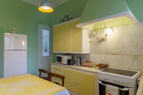 a kitchen with yellow cabinets and a sink and a table at Chrysoula's Vintage Home in Chios