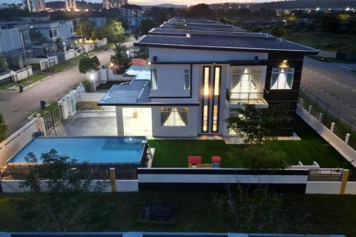 ein großes Haus mit einem davorliegenden Swimmingpool in der Unterkunft TropINN Villa- CornerHouse•BIGPool•BBQ•KTV•Billard in Bandar Penawar