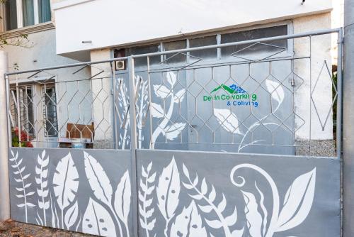 a fence with a mural of leaves on it at DevIn Coworking & Coliving in Devin