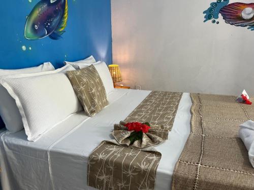 a bedroom with a bed with a flower on it at Pousada Nascente do Sol in Ilha de Boipeba