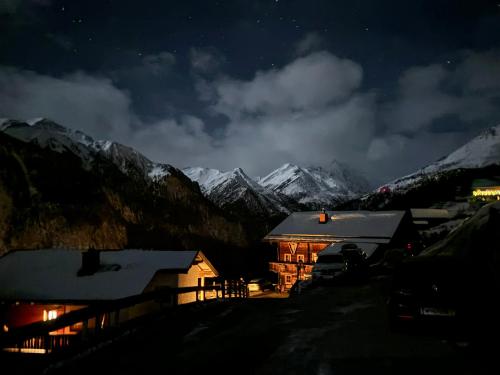 a house at night with snow covered mountains at Ferienhaus Gompitzer in Heiligenblut