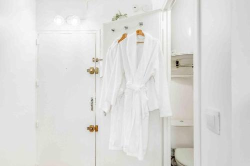アティス・モンスにあるLe Boudoir, studio chic Aéroport d’Orlyの白いバスローブがバスルームに掛けられている
