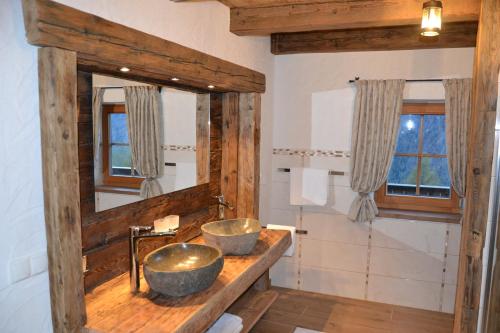 a bathroom with two sinks on a wooden counter at Ferienhaus Gompitzer in Heiligenblut