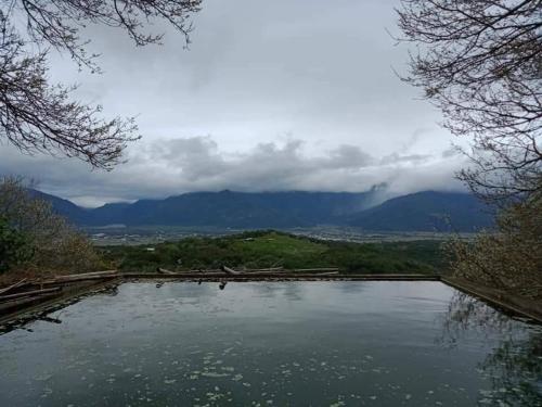 a large pool of water with mountains in the background at 梅園小築民宿 in Chishang