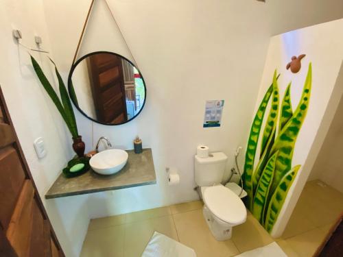 a bathroom with a toilet and a sink and a mirror at Pousada Nascente do Sol in Ilha de Boipeba
