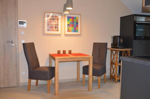 a kitchen with a table with chairs and a microwave at Ferienwohnung, 1-Zimmer, 1-3 Personen, 31 qm, mit Balkon, in ruhige Lage, direkt an der Aach in Singen