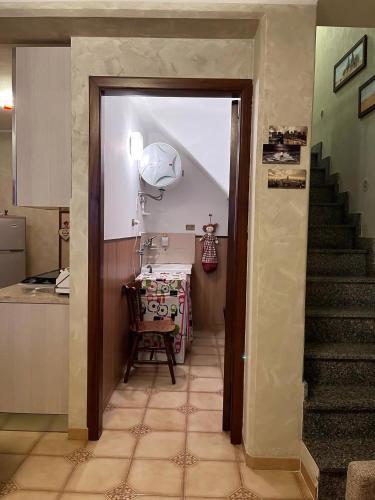 a hallway with a staircase and a kitchen with a table at Dimora dell'Etna in Randazzo