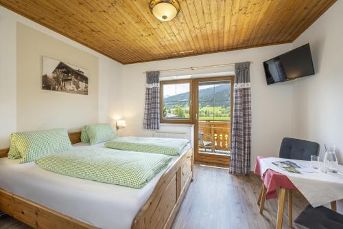 a bedroom with a bed and a desk and a window at Landhaus Aubauerngut in Radstadt