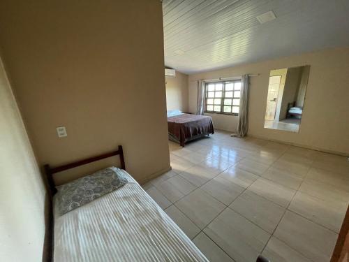 Großes Zimmer mit einem Bett und einem Fenster in der Unterkunft Casa do alto pipa in Pipa