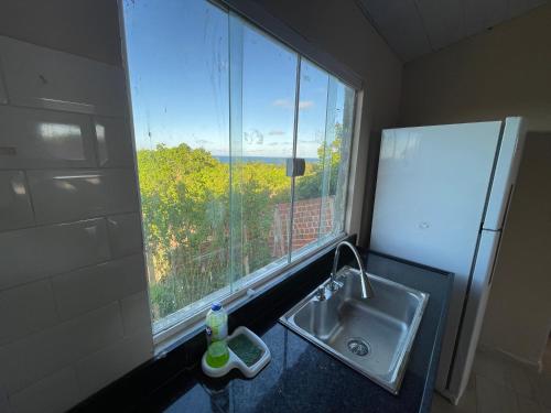 eine Küche mit einem Waschbecken und einem großen Fenster in der Unterkunft Casa do alto pipa in Pipa