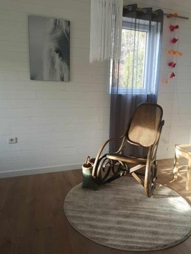 a rocking chair sitting on a rug in a room with a window at Gîte La Lisière in Sparsbach