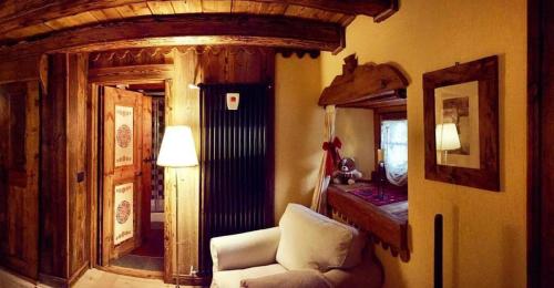 a living room with a chair and a mirror at B&B Lo Djoua de Toueno in Arvier