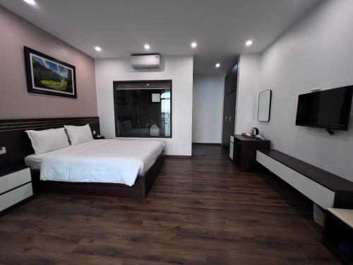 a bedroom with a bed and a flat screen tv at Lotus Hotel Ninh Bình in Ninh Binh