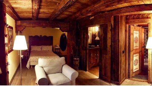 a bedroom with a bed and a couch and a chair at B&B Lo Djoua de Toueno in Arvier